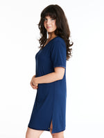 A woman wearing a short-sleeved, scoop-neck, knee-length nightie in a solid color, with satin trim detailing.