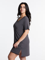 A woman wearing a short-sleeved, scoop-neck, knee-length nightie in a solid color, with satin trim detailing.