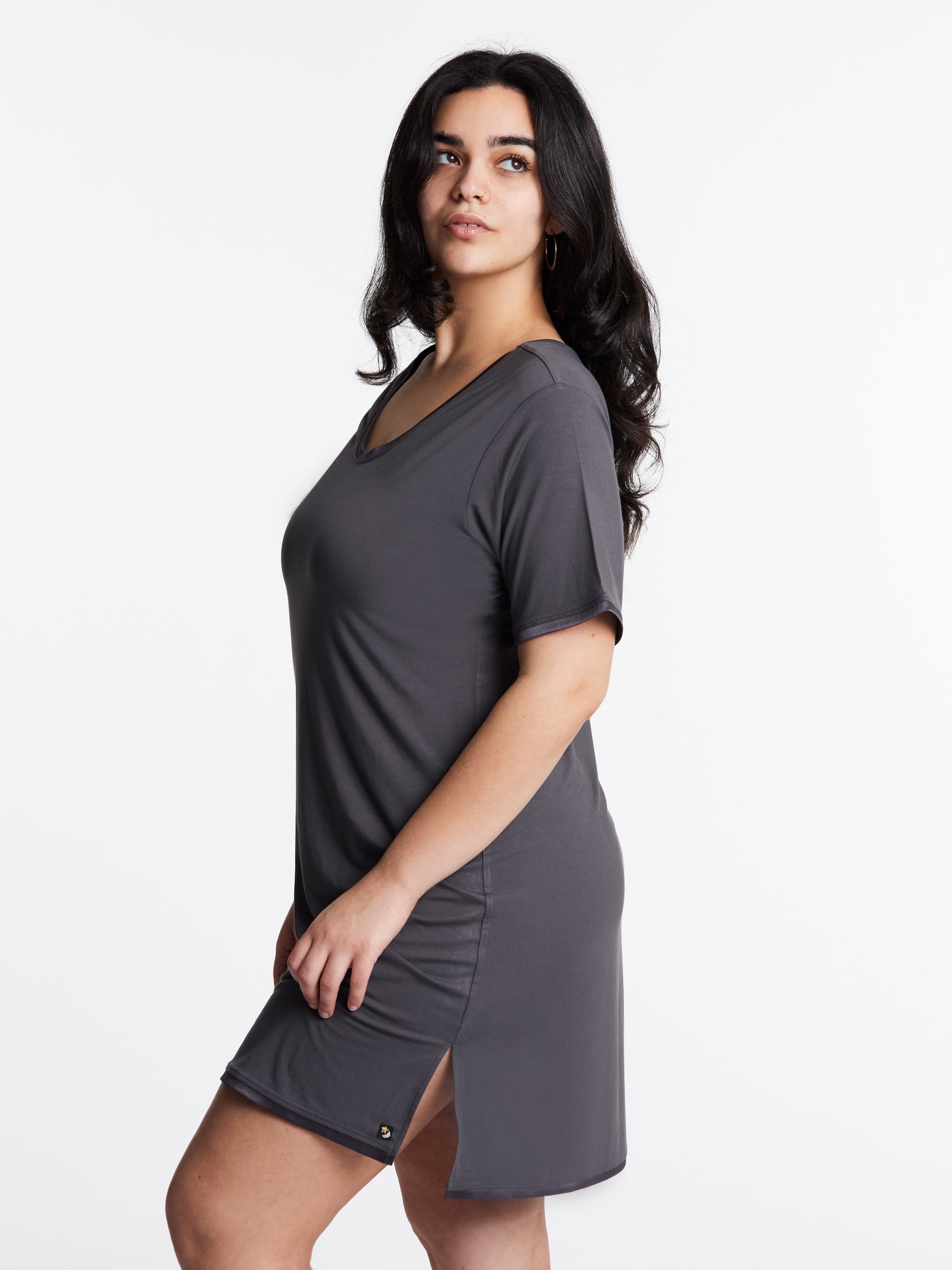 A woman wearing a short-sleeved, scoop-neck, knee-length nightie in a solid color, with satin trim detailing.