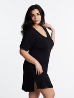 A woman wearing a short-sleeved, scoop-neck, knee-length nightie in a solid color, with satin trim detailing.