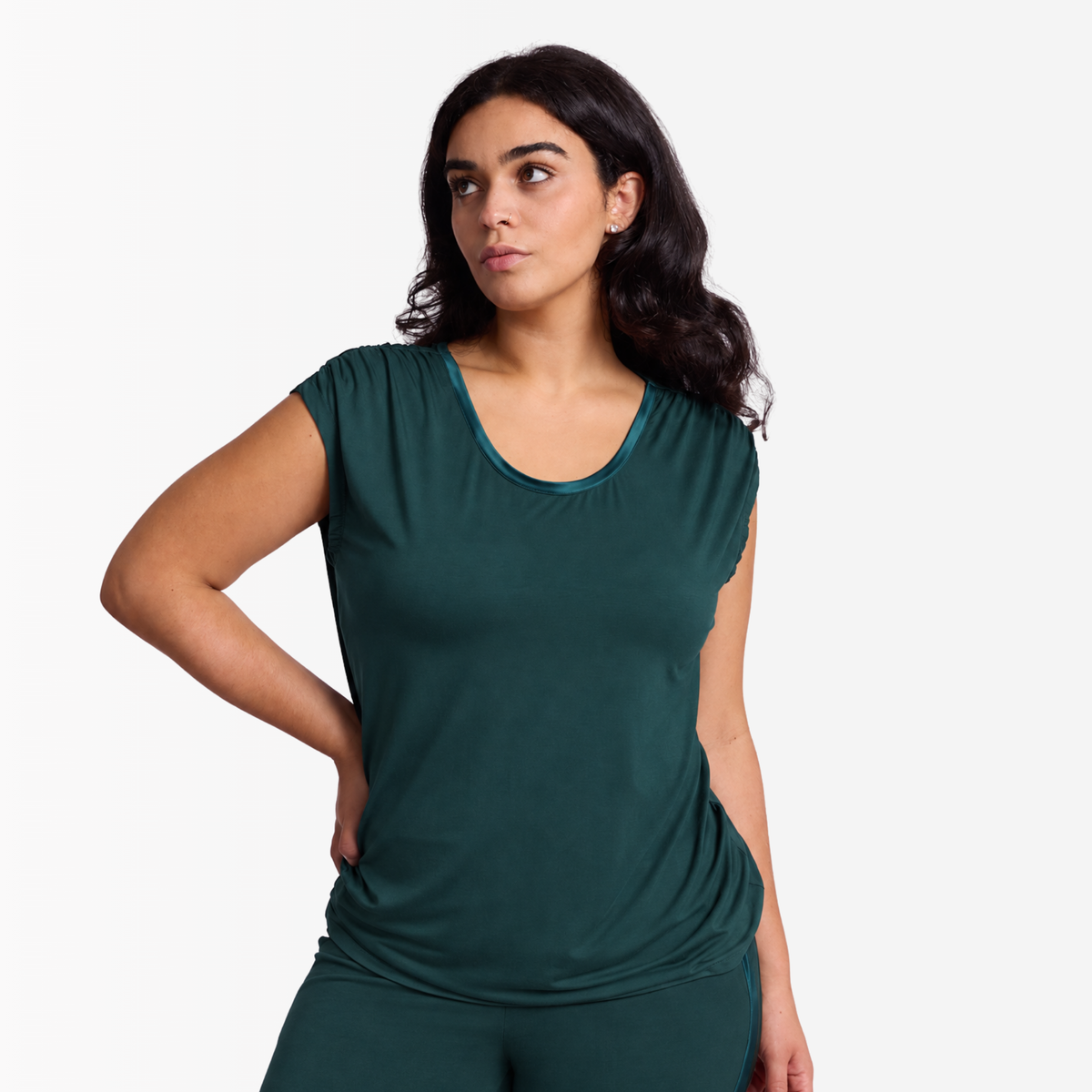 Woman in Ruched shoulder bamboo top in Dusky Jade against a white photography background