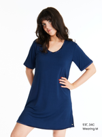 A woman wearing a short-sleeved, scoop-neck, knee-length nightie in a solid color, with satin trim detailing.