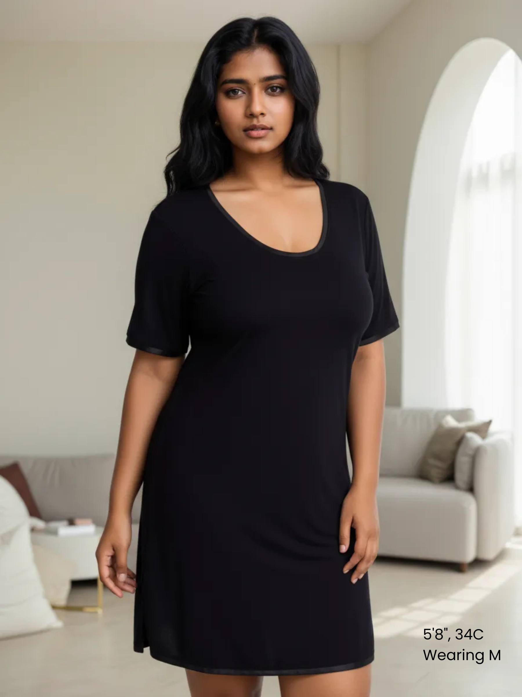 A woman wearing a short-sleeved, scoop-neck, knee-length nightie in a solid color, with satin trim detailing.